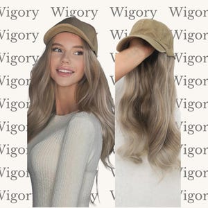 May include: A woman wearing a light brown cap with long, wavy blonde hair. The cap has a curved brim and a darker brown top. The background features the word "Wigory" repeated in a pattern.