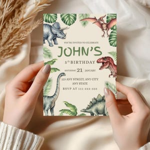 K&ouml;nnte beinhalten: Eine Geburtstagseinladung mit Illustrationen von Dinosauriern und tropischen Bl&auml;ttern. Der Text lautet "John's 5th Birthday" mit Datum und RSVP-Informationen. Die Einladung wird von einer Person gehalten.
