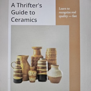 May include: Book cover titled "A Thrifter's Guide to Ceramics" with a collection of ceramic vases in shades of brown, tan, and white. The text "Learn to recognize real quality - fast" is also visible. The author's name, Virginia De La Cruz, is at the bottom.