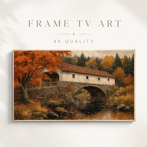 May include: Digital artwork titled FRAME TV ART 4K QUALITY featuring a landscape painting of a stone arched bridge with a white wooden roof over a stream, surrounded by autumn trees with orange foliage and three deer standing in the water.