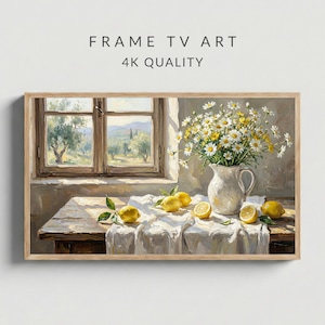 以下が含まれることがあります： 額縁に入った絵画は、レモン、白い水差しに入ったデイジー、風景を望む窓のある静物画を描いています。絵画には「FRAME TV ART 4K QUALITY」というテキストがあります。レモンは丸ごととスライスされ、白いテーブルクロスの上に配置されています。