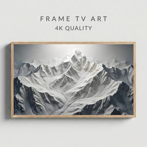 May include: A framed digital art print featuring a snow-covered mountain range. The artwork is in shades of white and gray, with the text "FRAME TV ART" and "4K QUALITY" at the top. The frame is made of light-colored wood.