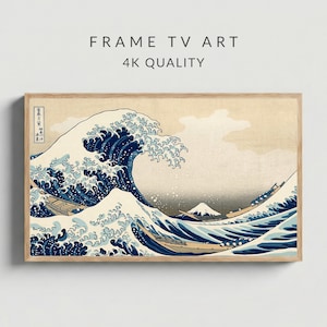 May include: A framed print of Hokusai's "The Great Wave off Kanagawa." The artwork shows a large ocean wave with boats and Mount Fuji in the background. The frame is made of light-coloured wood. Text on the print reads "FRAME TV ART" and "4K QUALITY."