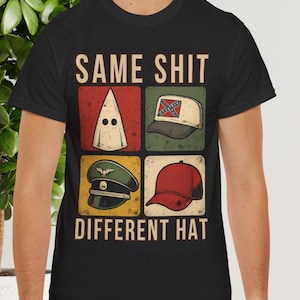 以下が含まれることがあります： 「SAME SHIT DIFFERENT HAT」の文字が上下に配置された黒いTシャツ。白いフード、南軍旗の野球帽、軍帽、赤い野球帽の4つの帽子の画像が描かれています。