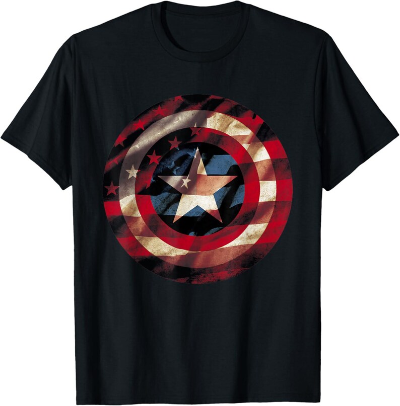 May include: Black t-shirt featuring a distressed graphic of a shield with red and white stripes, a blue center with a white star, and smaller white stars. The design is reminiscent of a patriotic emblem.