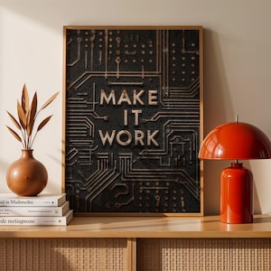 May include: A framed artwork with the text "MAKE IT WORK" in bold letters, set against a circuit board design. A red table lamp and a brown vase with decorative branches sit on a wooden cabinet.