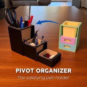 Op de afbeelding: Een zwart-beige draaibare organizer met meerdere compartimenten, met pennen, scharen en andere kantoorbenodigdheden. Een aparte, kleinere organizer in pastelkleuren is ook afgebeeld. De tekst luidt "PIVOT ORGANIZER The satisfying pen holder."