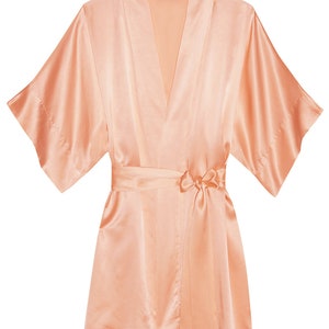 May include: A peach-colored satin robe with a self-tie sash. The robe has a V-neck and short sleeves.
