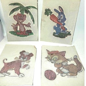 May include: Four vintage cartoon character images on paper. A monkey under a palm tree, a blue rabbit with a carrot, a brown dog with a bone, and a brown cat with a ball of yarn. Each image is on a separate paper.