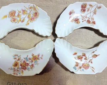Juego de 4 platos de hueso con forma de media luna y diseño floral vintage, con borde dorado festoneado.