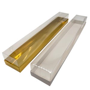 Op de afbeelding: Twee heldere, rechthoekige dozen met transparante deksels. Eén doos heeft een goudkleurige basis, de andere een grijze basis. Beide dozen zijn leeg en klaar voor gebruik.