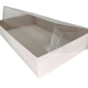 May include: A white rectangular box with a clear plastic lid. The lid is partially open, revealing the interior of the box. The box is made of a sturdy material and is suitable for packaging or storage.