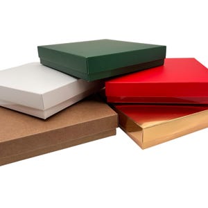 May include: A white ceramic mug with a black handle and the text "But First, Coffee" in a handwritten style. The mug is on a white surface. The mug is 10 cm tall.