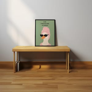 Puede incluir: Una impresi&oacute;n art&iacute;stica enmarcada que presenta un ganso de dibujos animados con gafas de sol y una toalla rosa en la cabeza. La impresi&oacute;n tiene el texto: "I lied. I won't be ready in 5 minutes." La obra est&aacute; sobre un banco de madera.