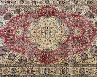 May include: A rectangular area rug featuring a central cream-colored medallion surrounded by a deep red field. The design includes intricate floral motifs, scrolling vines, and geometric patterns in shades of blue, brown, and beige with a wide border.