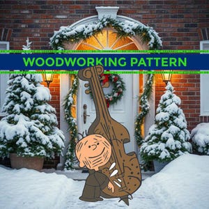 May include: A cartoon illustration of a character with a double bass, with the text "WOODWORKING PATTERN" in a green banner. The background shows a snowy winter scene with a decorated doorway and Christmas trees.