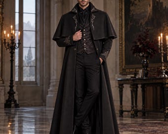 May include: A long black coat with a capelet overlay, featuring silver embroidery on the collar and cuffs. The coat is worn over a dark patterned vest with silver buttons, a black shirt, and black trousers, paired with black leather dress shoes.
