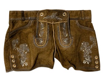 May include: Brown leather shorts with decorative embroidery and gold-colored buttons. The shorts feature detailed stitching and a classic design, suitable for traditional or themed events.