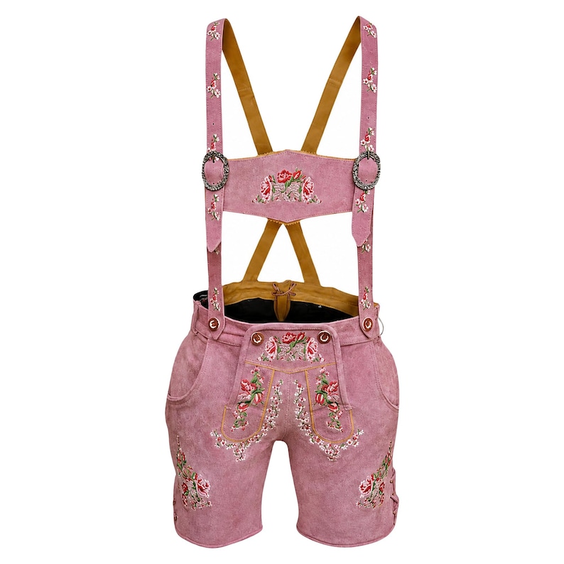 Puede incluir: Pantalones cortos lederhosen de cuero rosa con tirantes. Los pantalones cortos presentan bordados florales en la parte delantera, los laterales y los tirantes. Los tirantes tienen hebillas met&aacute;licas y se sujetan a los pantalones cortos con botones.