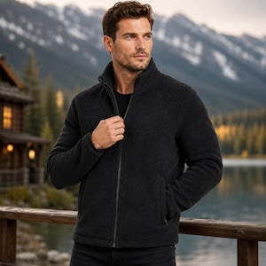 May include: A charcoal gray fleece jacket featuring a full-length front zipper, a high mock neck collar, and long sleeves. The jacket has a textured, soft-touch finish and includes two side pockets, providing a functional and warm outer layer.