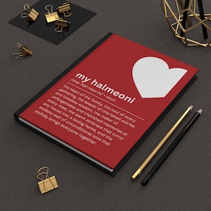 May include: A red journal with the text "my halmeoni" and a white heart graphic. The journal's description defines the term. Gold and black pencils, along with gold binder clips, are arranged around the journal.