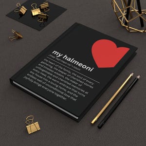 May include: Black notebook with the text "my halmeoni" and a red heart graphic. The notebook has a definition of the word "halmeoni" printed in white. Gold and black pencils and gold binder clips are also visible.