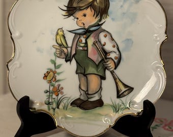 Prato decorativo Norcrest com desenho de um menino com um pássaro amarelo - marcado e etiquetado.