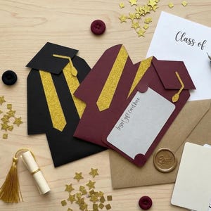 May include: A graduation-themed collection featuring black and maroon graduation gown gift card holders with gold accents. Includes a diploma scroll, confetti, cards that say "Congratulations!", and a paper that says "Class of".
