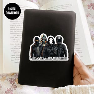 May include: A black sticker featuring four figures in masks and jackets. The sticker has the text "I LIKE MY MEN, MASKED, AND OBSESSED." A digital download label is in the upper left corner. The sticker is on a black surface.