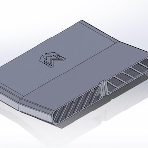 May include: A gray, rectangular, three-dimensional object with a flat top surface featuring an embossed letter M logo. The side profile displays a series of angled, hollow, parallel vents or slats that run along the length of the structure.