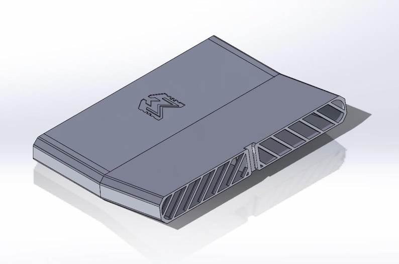 May include: A gray, rectangular, three-dimensional object with a flat top surface featuring an embossed letter M logo. The side profile displays a series of angled, hollow, parallel vents or slats that run along the length of the structure.