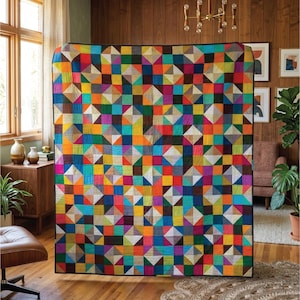 Puede incluir: Un edredón grande y colorido con un patrón geométrico de cuadrados y triángulos en varios colores, incluyendo rojo, azul, amarillo y verde. El edredón se exhibe en interiores, agregando un toque vibrante a la decoración de la habitación.