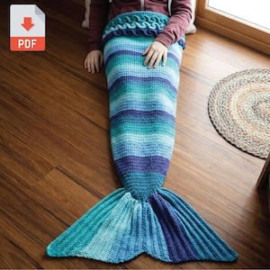 May include: A handmade crochet mermaid tail blanket in shades of blue, teal, and purple. The blanket features horizontal stripes and a detailed fin design. The PDF icon is in the upper left corner.