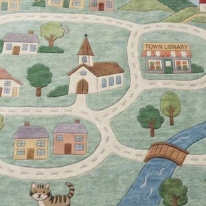 May include: A colorful rug depicting a town scene with roads, houses, a church, and a library. The rug features a river, a bridge, and illustrations of a dog, cat, sheep, and cow. The text "TOWN LIBRARY" is visible.
