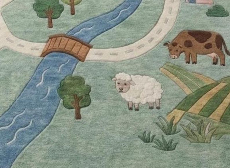 May include: A whimsical, illustrated rug featuring a pastoral scene. A blue river flows under a brown bridge, with a road winding alongside. A sheep and a cow graze on the green grass. Trees and fields complete the charming landscape.