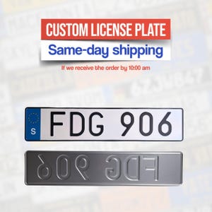 Op de afbeelding: Een witte nummerplaat met zwarte letters en cijfers, met de tekst "FDG 906". De plaat heeft een blauw symbool van de Europese Unie en de letter "S". Daaronder een grijze, in reliëf gemaakte nummerplaat met dezelfde tekst in omgekeerde volgorde. Bovenin staat "CUSTOM LICENSE PLATE".