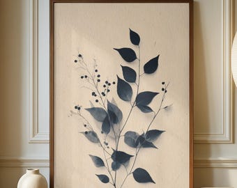 Könnte beinhalten: Ein gerahmter botanischer Druck mit einer Aquarellillustration von dunkelblauen Blättern und Beeren auf cremefarbenem Hintergrund. Das Kunstwerk wird auf einem Holzschrank mit einer weißen Vase und einer Stehlampe mit Papierschirm ausgestellt.