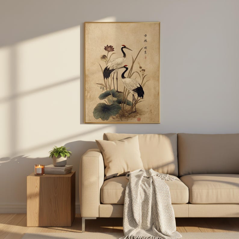 Puede incluir: Impresi&oacute;n art&iacute;stica enmarcada que representa dos grullas en un entorno natural. La obra de arte presenta las aves con plumaje blanco y negro, detalles rojos y largos picos. El fondo es beige apagado y el marco es dorado.