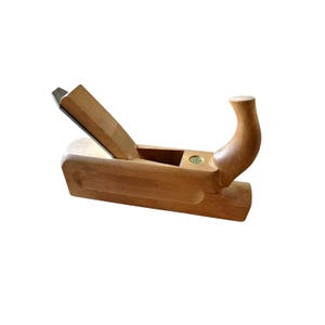 May include: A wooden hand plane, featuring a curved handle and a metal blade. The plane is constructed from light-coloured wood and has a rectangular body. The blade is angled and positioned near the front. The handle curves upwards, offering a comfortable grip.