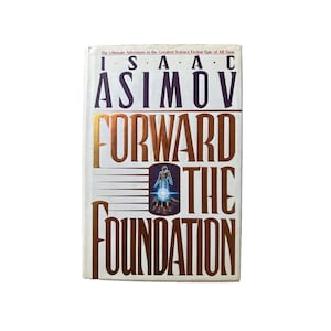 Puede incluir: Un libro de tapa dura titulado "Forward the Foundation" de Isaac Asimov. La portada es blanca con letras doradas y marrones. El libro presenta un tema de ciencia ficción con una ilustración de una figura con un brillo azul.