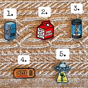 Puede incluir: Colección de parches bordados con varios diseños. Incluye un refrigerador con el texto "little cooler", un cartón de leche rojo con texto, una lata azul con una persona bajo un paraguas, un boleto y un OVNI con un alienígena.