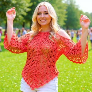 May include: A coral-colored, open-weave crochet top with long, flared sleeves. The top has a unique shoulder cut-out design and is paired with white shorts. The image is taken outdoors on a sunny day with a green grassy background.