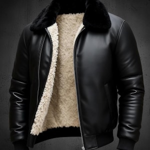May include: Black leather jacket featuring a black faux fur collar and a cream-coloured, fuzzy interior lining. The jacket has a zip closure and ribbed cuffs and hem. A classic bomber jacket style.