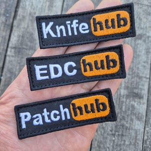 May include: Three black rectangular patches with white text and an orange hub logo. The patches read "Knife hub", "EDC hub", and "Patch hub". The patches are embroidered with a black border.