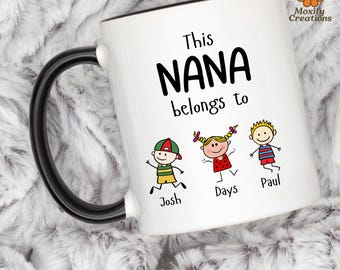 May include: White ceramic mug with a black handle and rim. The mug features the text "This NANA belongs to" above three cartoon children with the names Josh, Days, and Paul. The mug has a floral logo.