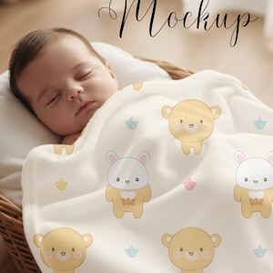 May include: A baby blanket with a repeating pattern of cartoon bears in yellow, white, and gray, along with small blue and pink crown shapes. The blanket is draped over a baby in a wicker basket. The text "BABY BLANKET Mockup" is at the top.