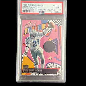May include: A Deion Sanders 2025 Donruss Elite Throwback Threads Singles trading card, graded Mint 9, encased in a protective holder. The card features a pink, black, and white design with the text "Throwback Threads" and "Deion Sanders".