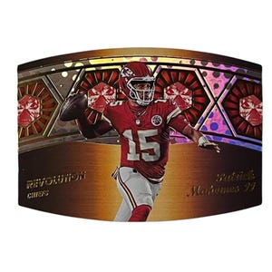 May include: A rectangular sports trading card featuring Patrick Mahomes in a red Kansas City Chiefs uniform with the number 15. The card has a metallic bronze background with a geometric pattern, the text REVOLUTION, CHIEFS, and Patrick Mahomes 15.