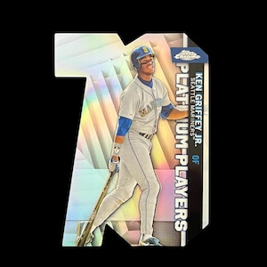 May include: A baseball card featuring Ken Griffey Jr. of the Seattle Mariners. The card has a holographic background and the words "Platinum Players" are printed on the right side. Griffey is wearing a Mariners uniform and holding a baseball bat.