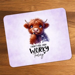 May include: A square mousepad with a light purple background featuring a cartoon illustration of a Highland cow. The cow has brown fur, small horns, and is wearing a blue plaid shirt. Text reads "I don't feel very worky today."